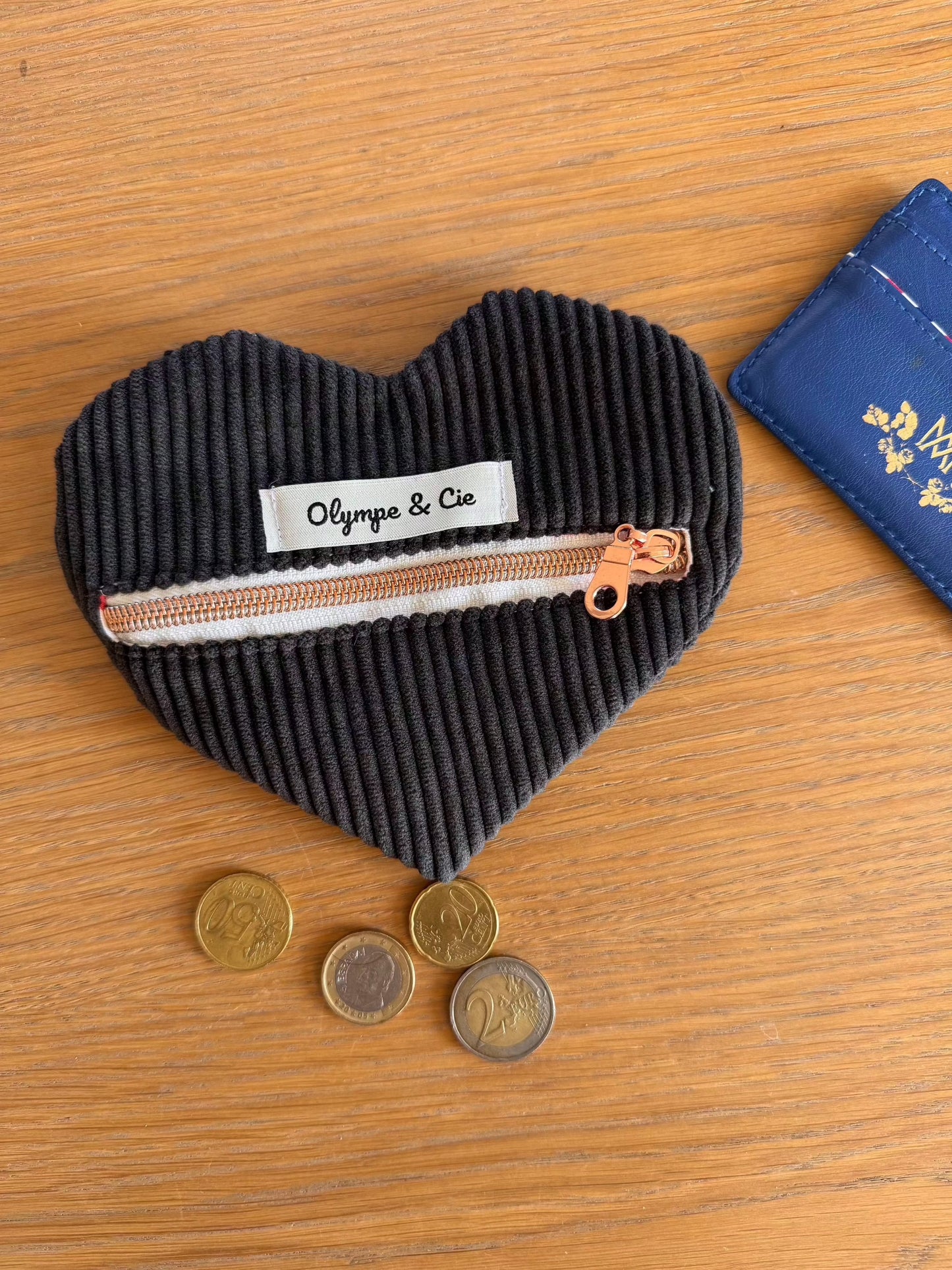 Porte-monnaie velours noir en forme de cœur avec fermeture éclair et étiquette "Olympe & Cie".