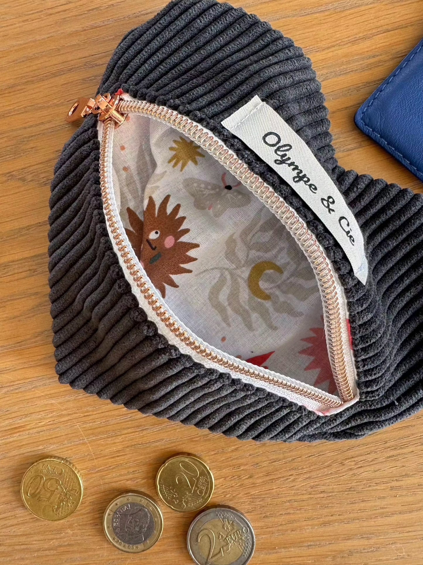 Porte-monnaie velours noir en forme de cœur avec fermeture éclair et étiquette "Olympe & Cie".