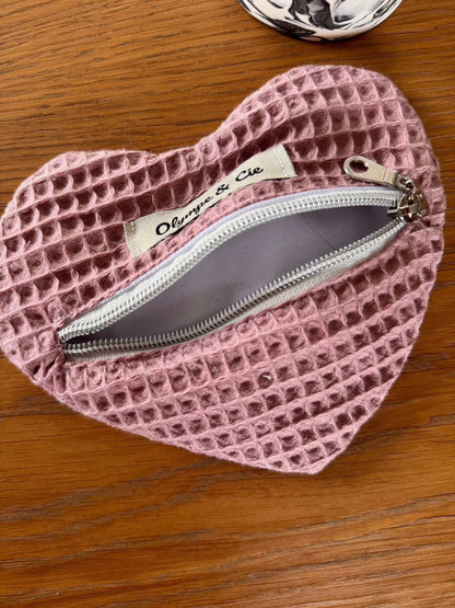 Porte-monnaie rose en forme de cœur avec fermeture éclair et étiquette "Olympe & Cie".